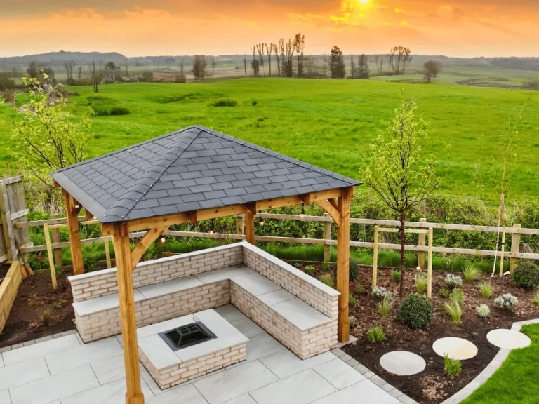 Expertly designed modern patio featuring a wooden gazebo, built-in brick fire pit, and stone L-shaped bench seating.