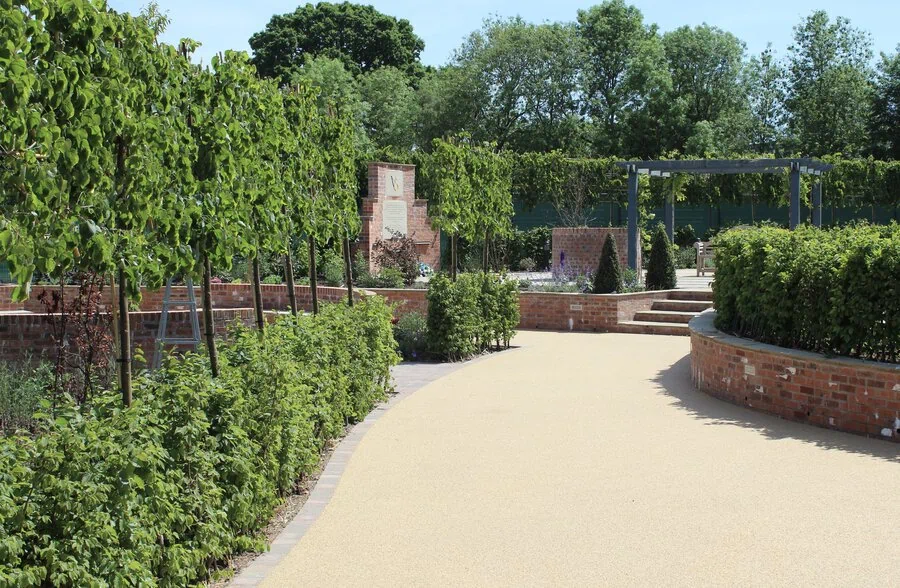 Brick edged resin path through a walled garden