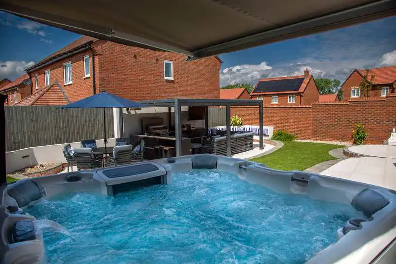 Luxury hot tub garden with pergola, lawn and paved terrace in Leicestershire