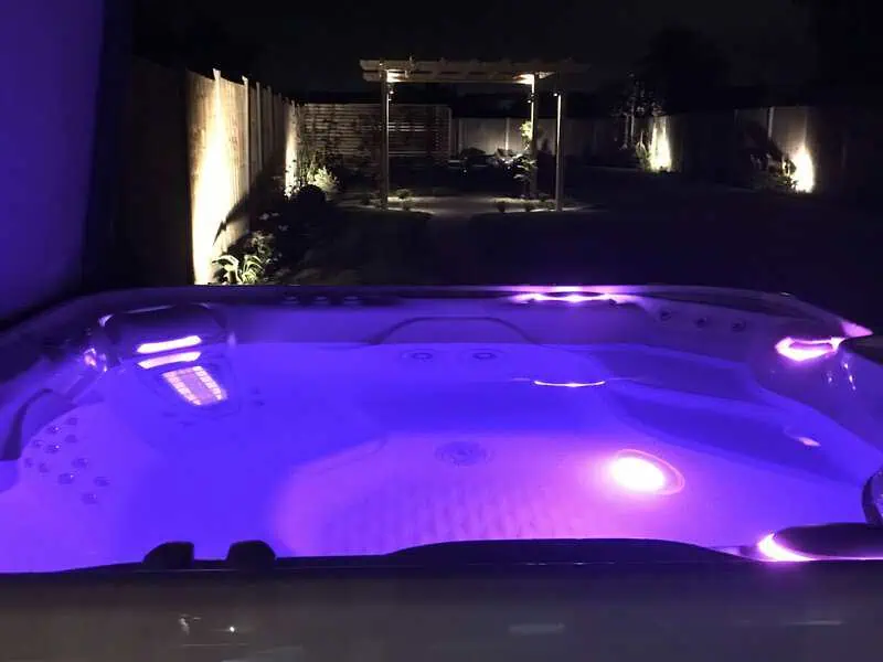 Luxury hot tub with purple lighting in a private evening garden