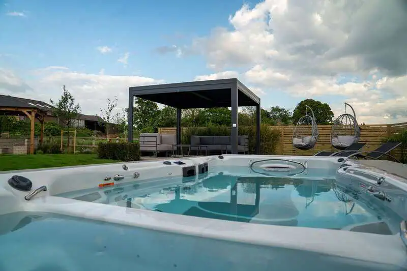 Hot tub and pergola integrated into a landscaped garden