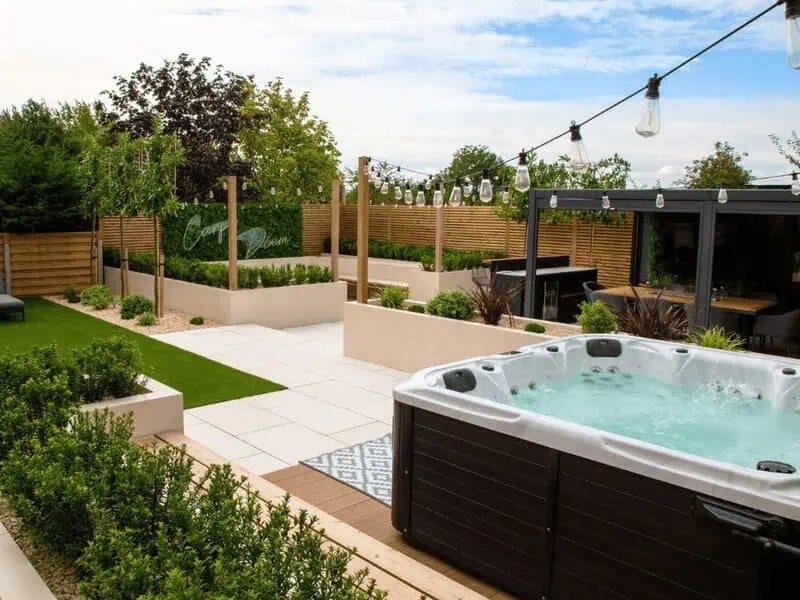 Daytime spa garden with porcelain paving, pergola and planted borders